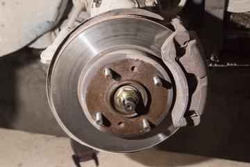 Car under repair on hoist at service station.