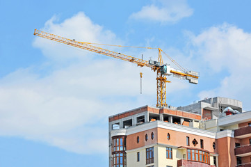 Crane and building construction site against blue sky