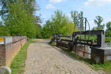 Old cobblestone road over bridge and sluice