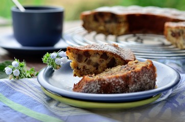 Сake with chocolate and banana on the blue plate in the garden
