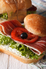 Sandwich with jamon, cheese and vegetables closeup vertical
