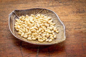 bowl of pine nuts on rustic wood