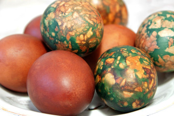 Obraz na płótnie Canvas Colorful Easter eggs on white plate placed by heap