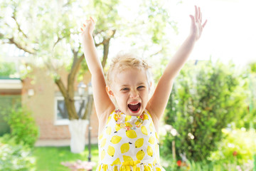 Portrait of emotional little girl in summer dress outdoor