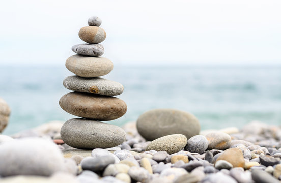 Round Smooth Stones Stacked on Rocky Beach - Powered by Adobe