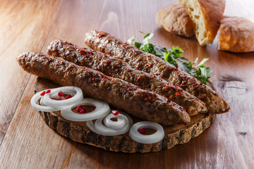 lula kebab with herbs on a wooden surface
