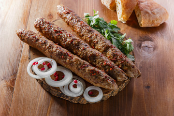 lula kebab with herbs on a wooden surface