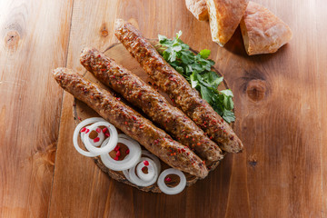 lula kebab with herbs on a wooden surface