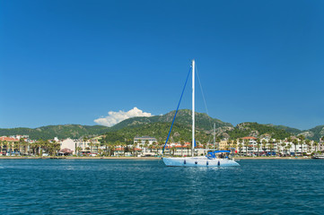 Fototapeta na wymiar white yacht near beach with mountains at back