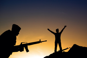 Fototapeta na wymiar Silhouette shot of soldier holding gun