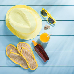 Summer accessories on blue wooden background top view