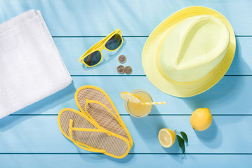 Summer accessories on blue wooden background top view