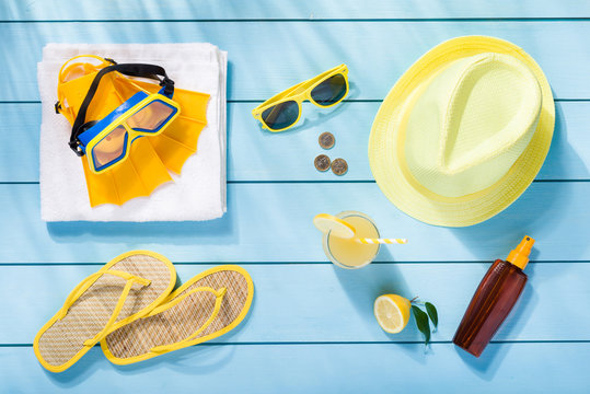 Summer accessories on blue wooden background top view