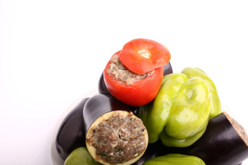 Stuffed eggplant pepper tomato cabbage leaves ground meat with rice and green on a white background