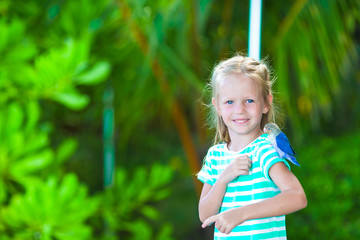 Adorable happy girl at beach with colorful little bird