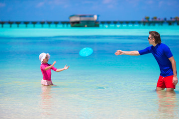 Happy little girl with young dad have fun on tropical beach