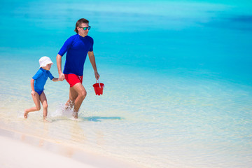 Happy family having fun on white tropical beach