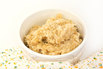 breakfast oatmeal in a white ceramic bowl shabby chic vintage retro selective soft focus