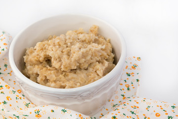 breakfast oatmeal in a white ceramic bowl shabby chic vintage retro selective soft focus