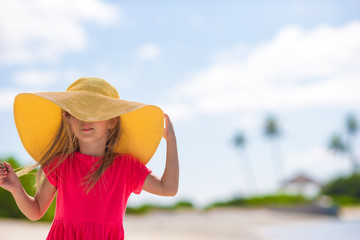 Adorable little girl in hat at beach during summer vacation