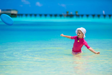 Fototapeta na wymiar Adorable happy little girl have fun at shallow water on beach