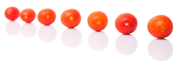 Bite sized red cherry grape tomato over white background