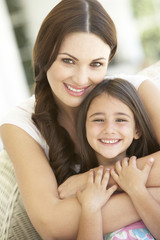 Fototapeta premium Mother And Daughter Relaxing Together In Chair