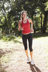 Young Woman Running Along Woodland Path