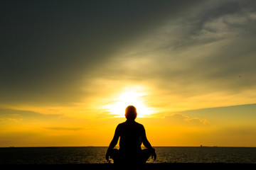 Stock Photo - Woman doing yoga at sunset