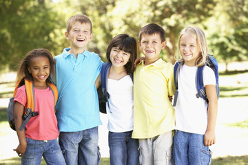 Fototapeta na wymiar Group Of Primary School Pupils Wearing Backpacks In Park