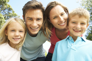 Close Up Of Family Group Looking Into Camera In Park