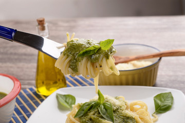 Spaghetti al pesto with basil leaves