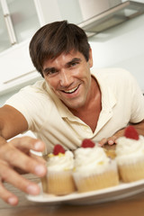 Man Eating Cakes In Kitchen