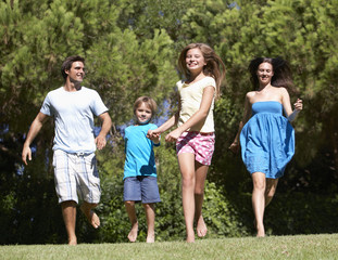 Obraz premium Young Family Running Through Summer Field