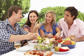 Group Of Young Friends Enjoying Outdoor Meal Together