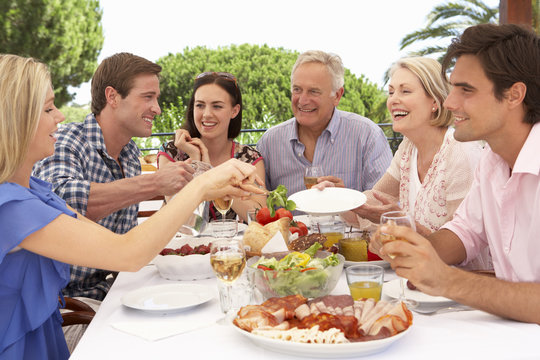 Extended Family Group Enjoying Outdoor Meal Together