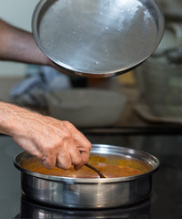 Man Stirring Pan of Sauce on Stove top