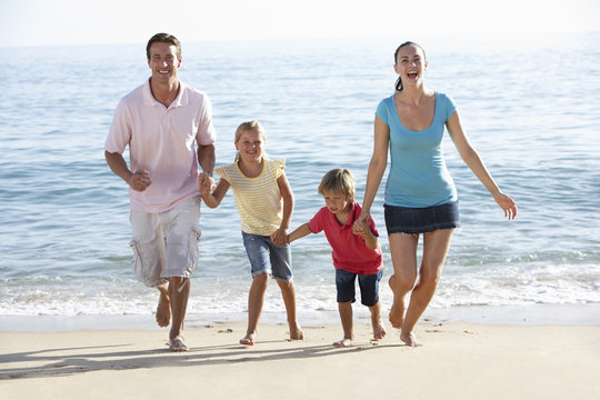 Running Family On Beach Holiday