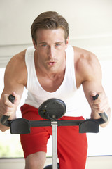 Young Man On Exercise Bike
