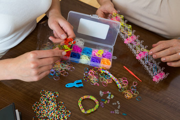 Closeup of  making decorative bracelets with colorful  bands