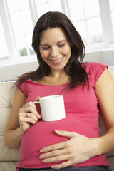 Pregnant Woman Drinking Hot Drink At Home