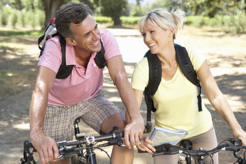 Middle Aged Couple Cycling Through Countryside