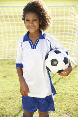 Young Boy Dressed In Soccer Kit Standing By Goal