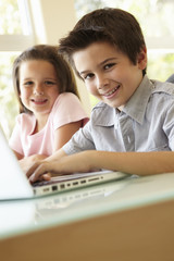 Hispanic Boy And Girl Using Laptop