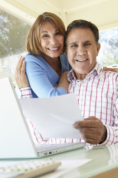 Senior Hispanic Couple Working In Home Office