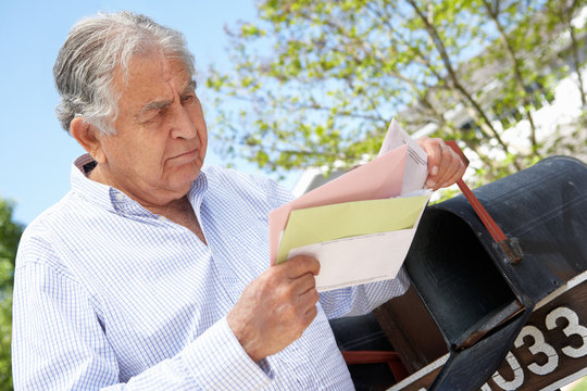 Worried Senior Hispanic Man Checking Mailbox