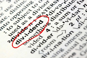 Closeup of the word dividend in the English dictionary
