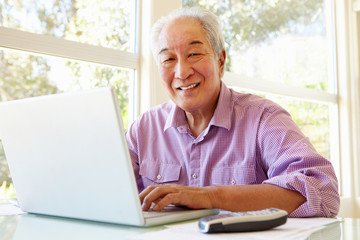 Fototapeta na wymiar Senior Taiwanese man working on laptop