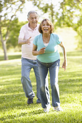 Fototapeta premium Senior Hispanic Couple Running In Park