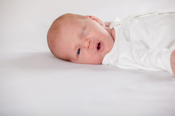 Newborn baby peacefully lying, on a white background